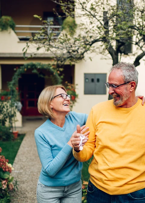 A couple celebrating outside their home